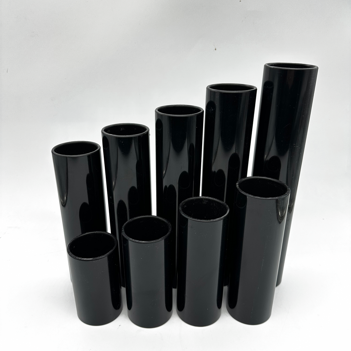 Set of black cylindrical vases on a white background