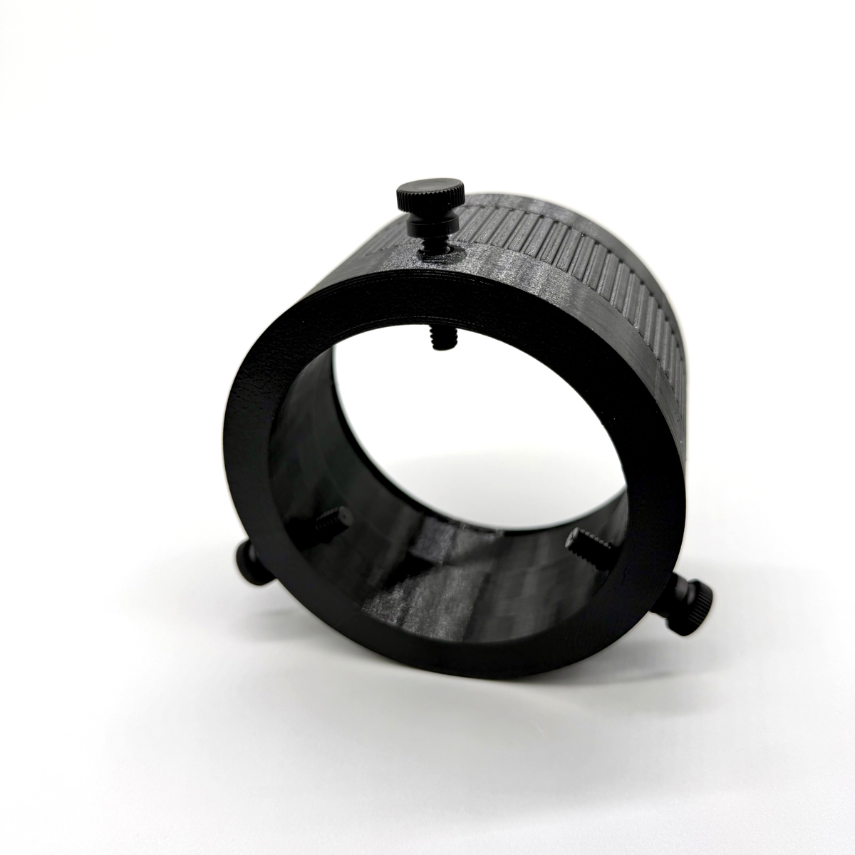 Black metal ring with a central screw on a white background. Black metal ring with a textured surface on a white background. Porthole Mark II Studio Upper Assembly